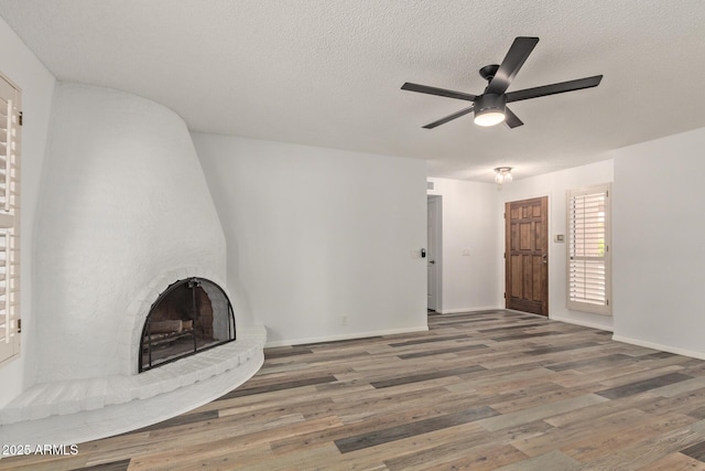 9845 W Behrend Dr, Peoria, AZ 85382 - unfurnished living room with a textured ceiling, baseboards, ceiling fan, and wood finished floors