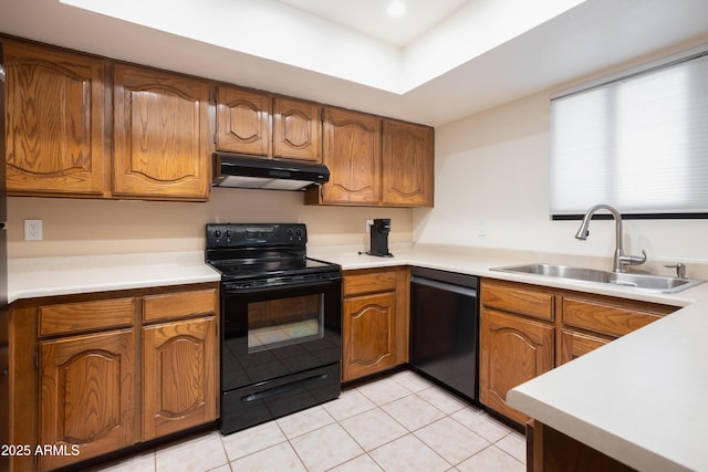 kitchen featuring dishwashing machine, brown cabinetry, a sink, under cabinet range hood, and black electric range oven