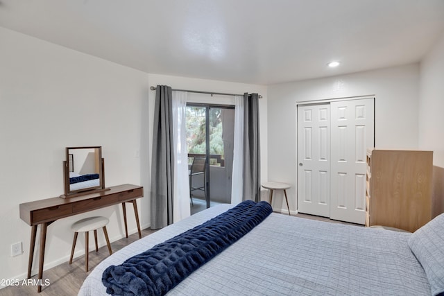 bedroom with access to exterior, a closet, baseboards, and wood finished floors