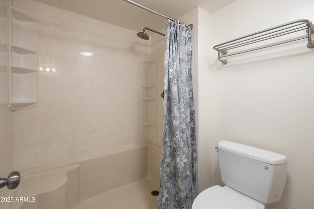 bathroom featuring a shower with shower curtain and toilet