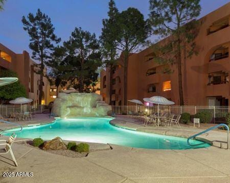 community pool with a patio and fence