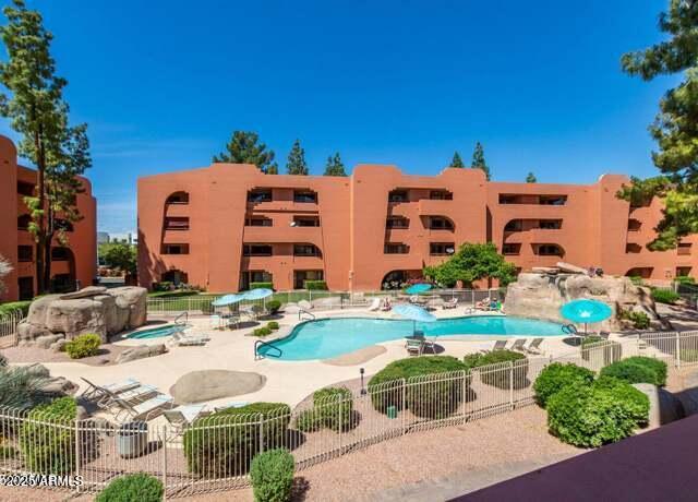 community pool with a patio area and fence