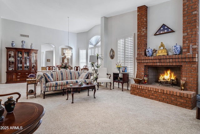 carpeted living room with a towering ceiling and a fireplace