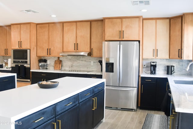 kitchen with sink, black appliances, a kitchen island, and backsplash