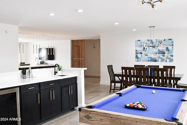 recreation room with light hardwood / wood-style flooring, sink, beverage cooler, and pool table