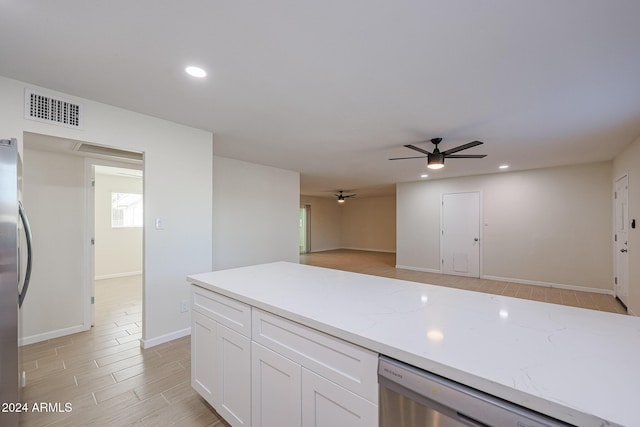 kitchen featuring light stone countertops, white cabinets, stainless steel appliances, and light hardwood / wood-style floors