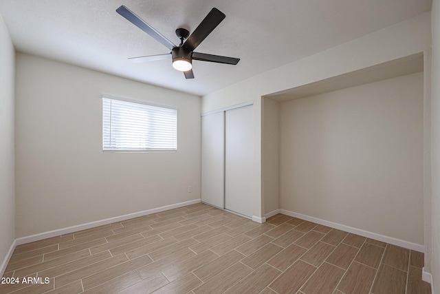 unfurnished bedroom featuring ceiling fan and a closet