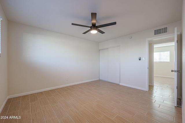 unfurnished bedroom with ceiling fan, a closet, and light hardwood / wood-style flooring