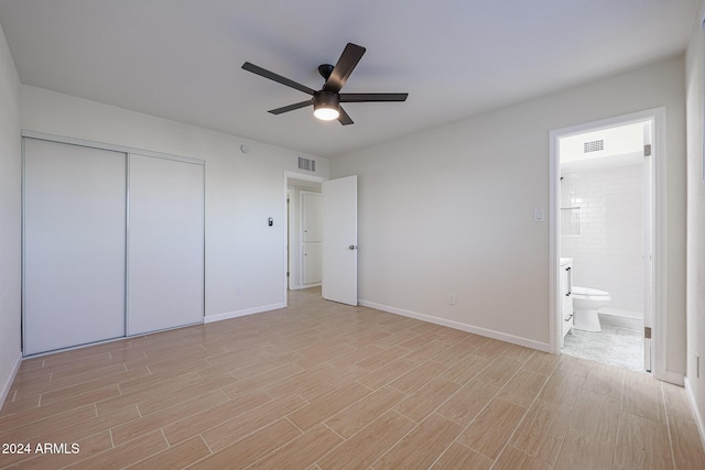 unfurnished bedroom with ensuite bath, a closet, and ceiling fan