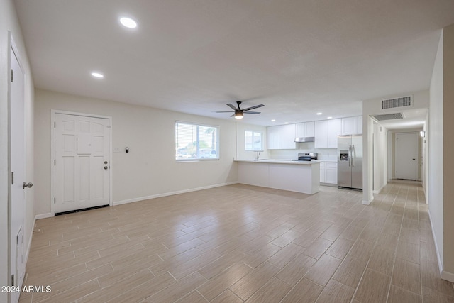 unfurnished living room with ceiling fan and light hardwood / wood-style flooring