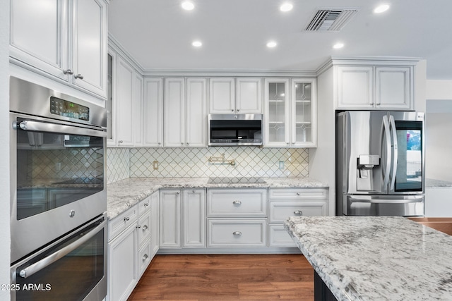 kitchen featuring white cabinetry, light stone countertops, and appliances with stainless steel finishes