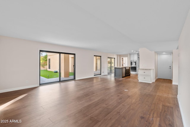 unfurnished living room with a healthy amount of sunlight and dark hardwood / wood-style floors