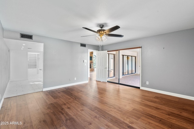 spare room with ceiling fan and light wood-type flooring