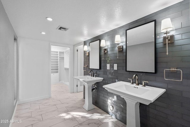 bathroom featuring dual sinks and a textured ceiling