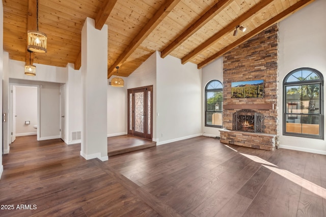 unfurnished living room featuring a stone fireplace, dark hardwood / wood-style floors, high vaulted ceiling, beamed ceiling, and wooden ceiling