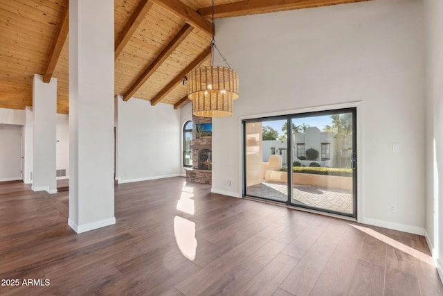 unfurnished living room featuring a stone fireplace, high vaulted ceiling, wooden ceiling, dark hardwood / wood-style floors, and beam ceiling