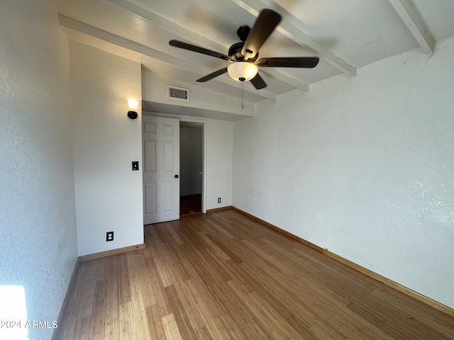 unfurnished room featuring wood-type flooring, lofted ceiling with beams, and ceiling fan