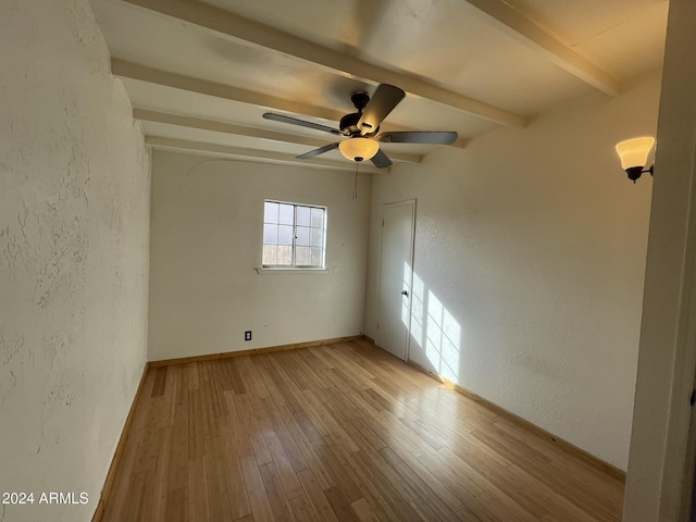 spare room with beamed ceiling, ceiling fan, and light hardwood / wood-style flooring