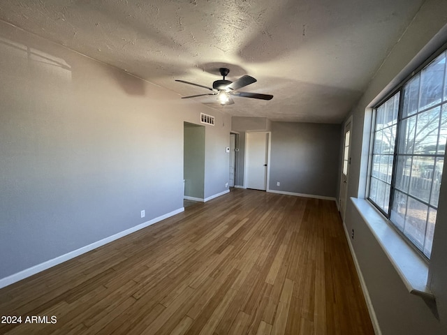 spare room featuring ceiling fan, wood-type flooring, and a textured ceiling