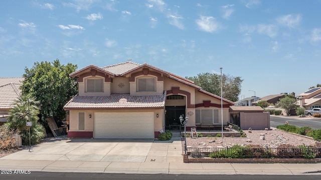 mediterranean / spanish home with a garage, fence, stucco siding, concrete driveway, and a tile roof