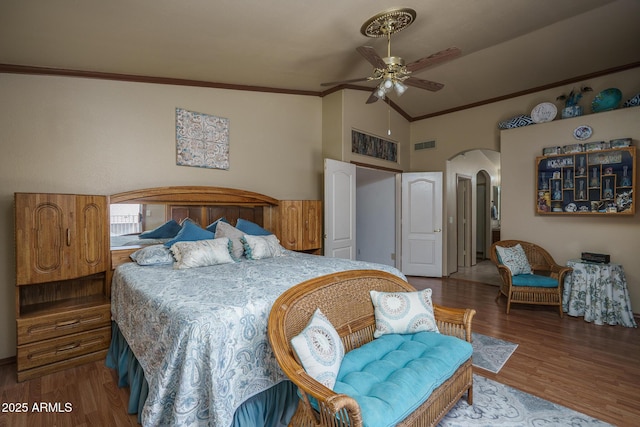 bedroom with visible vents, arched walkways, lofted ceiling, and wood finished floors