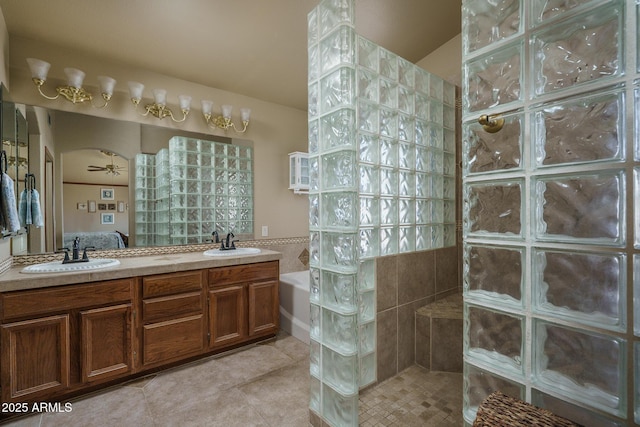 ensuite bathroom with connected bathroom, a walk in shower, a sink, and tile patterned flooring