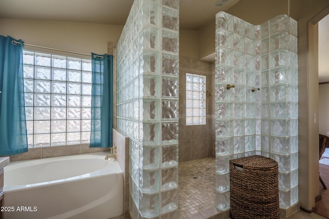 bathroom featuring walk in shower and a garden tub