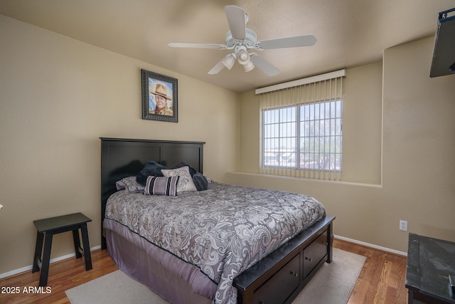 bedroom featuring baseboards, a ceiling fan, and wood finished floors