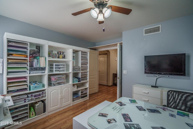 bedroom featuring a ceiling fan, wood finished floors, and visible vents