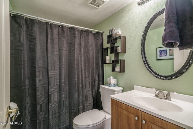 full bath featuring toilet, a textured wall, visible vents, and vanity
