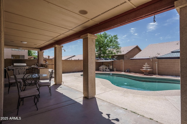 view of swimming pool featuring an outdoor kitchen, a fenced in pool, a fenced backyard, and a patio area