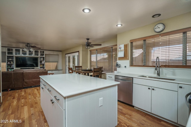 kitchen with a sink, light wood-style floors, dishwasher, a center island, and a ceiling fan