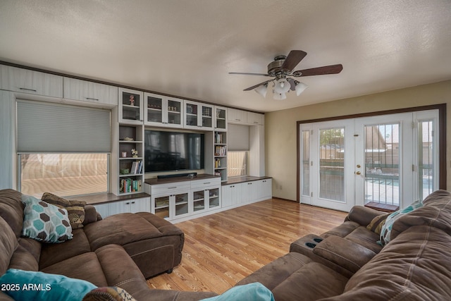 living area with ceiling fan, french doors, and light wood finished floors