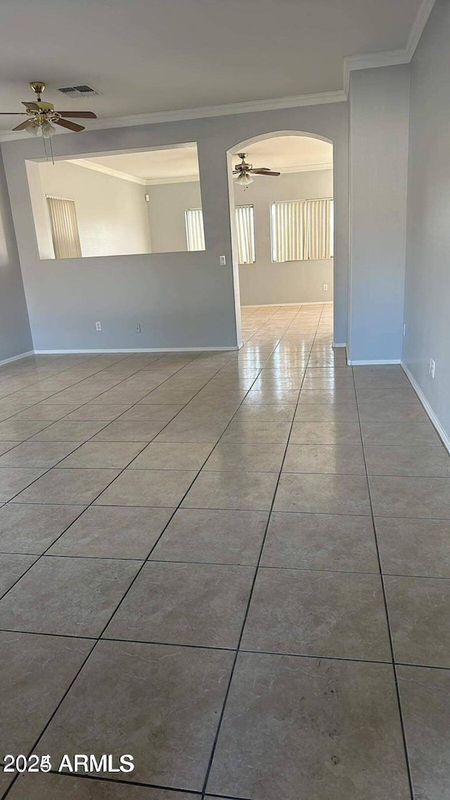 unfurnished room featuring ceiling fan, light tile patterned floors, and crown molding