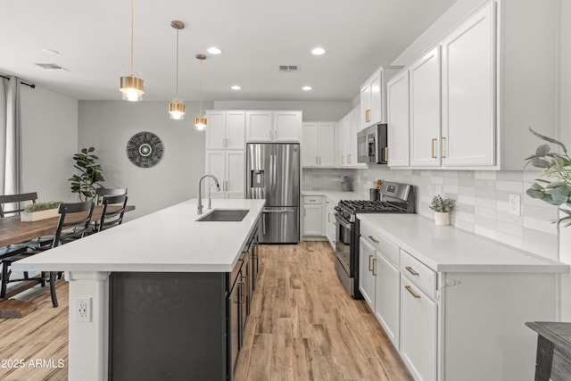 14435 W El Cortez Pl, Surprise, AZ 85387 - kitchen featuring appliances with stainless steel finishes, a sink, white cabinetry, tasteful backsplash, and recessed lighting