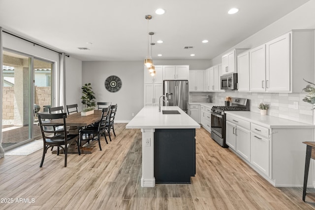 14435 W El Cortez Pl, Surprise, AZ 85387 - kitchen featuring appliances with stainless steel finishes, decorative backsplash, light wood-style flooring, white cabinetry, and light countertops