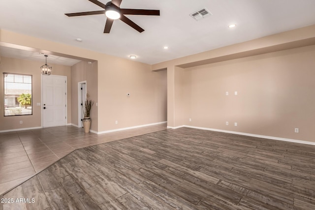 unfurnished living room featuring recessed lighting, baseboards, dark wood finished floors, visible vents, and ceiling fan with notable chandelier