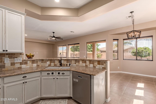 kitchen with stainless steel dishwasher, visible vents, a sink, a peninsula, and backsplash