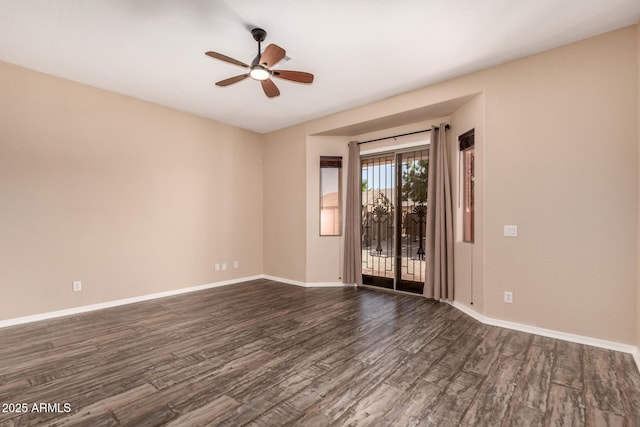 unfurnished room with baseboards, ceiling fan, and dark wood-type flooring