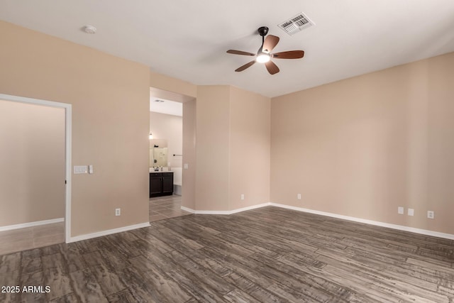 empty room featuring baseboards, a ceiling fan, visible vents, and wood finished floors