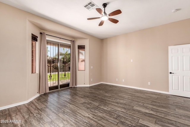 empty room featuring baseboards, dark wood-style flooring, visible vents, and ceiling fan