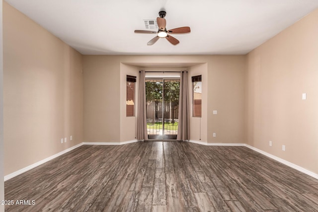 spare room featuring baseboards, wood finished floors, a ceiling fan, and visible vents