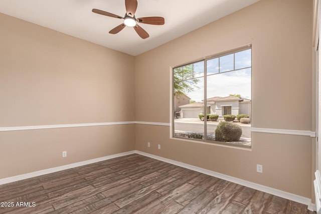 empty room with ceiling fan, baseboards, and wood finished floors