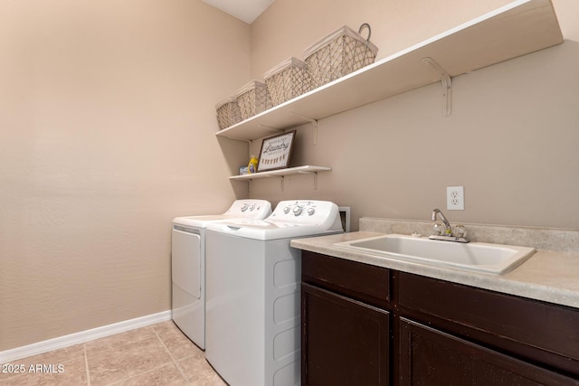 washroom with washing machine and dryer, light tile patterned floors, a sink, cabinet space, and baseboards