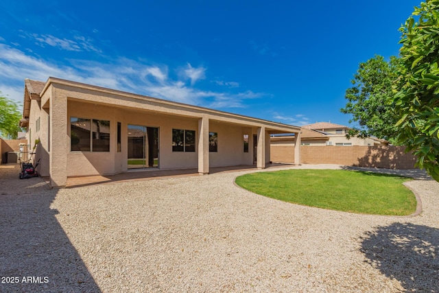 rear view of property with fence, a patio, and stucco siding