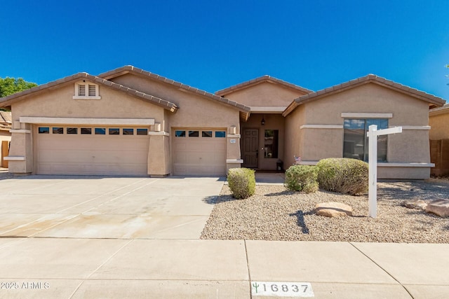 16837 W Northampton Rd, Surprise, AZ 85374 - view of front facade featuring a garage, concrete driveway, stucco siding, and a tiled roof