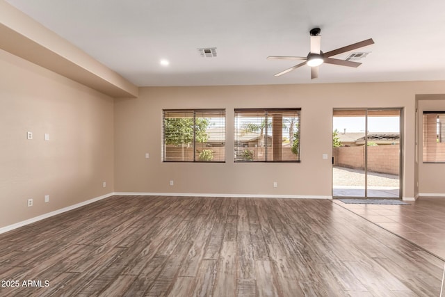 unfurnished room featuring ceiling fan, baseboards, dark wood-style floors, and visible vents