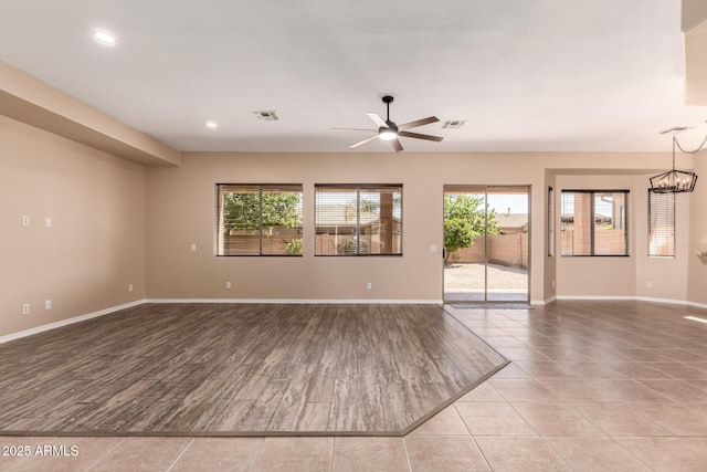 unfurnished living room featuring wood finished floors, ceiling fan with notable chandelier, visible vents, baseboards, and recessed lighting