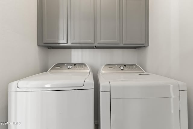 washroom featuring cabinets and washing machine and dryer