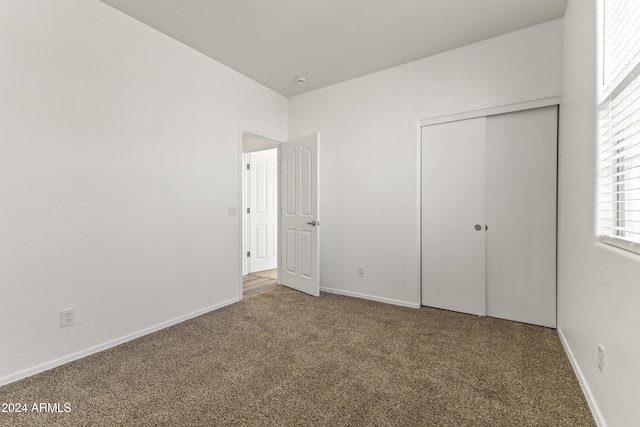 unfurnished bedroom featuring carpet and a closet